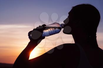 Rehydrate your body. Sporty woman drinking water outdoor on sunny day.