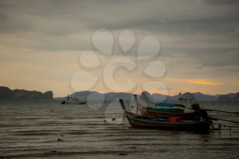 Beautiful sunset on the sea with traditional thai fishing longtail boats. Sunset at Loh Dalum Bay, Phi Phi Island, Krabi, Thailand.