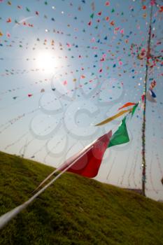 Multi-color triangle pray flags at Thai celebration festival with cloud and blue sky background. Songkran in Thailand of April. Thai new year national holiday.