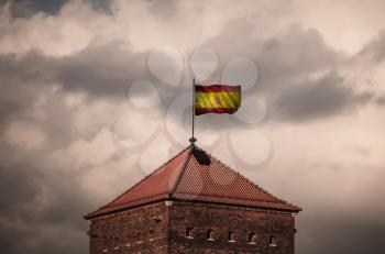 Flag with original proportions. Closeup of grunge flag of Spain beautiful flailing flag on the roof of the old fortress