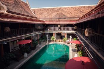 Asian style hotel in Thailand with old vintage decor. Pool bed in luxury hotel - vintage effect and sun flare filter processing