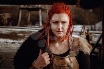 Viking girl. Reconstruction of a medieval scene. Against the backdrop of a large viking village.