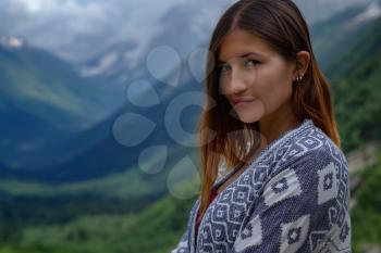 Stylish female hipster walking on top of mountains. Happy young woman exploring sunny mountains. Travel and wanderlust concept. Amazing atmospheric moment. North Caucasus, Dombai, Russia.