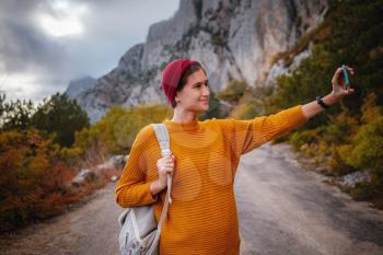 Outdoor fashion photo of young beautiful asian lady surrounded autumn forest in mountains. Portrait of romantic hipster female, Warm autumn weather, calm scene. Wanderlust photo series.
