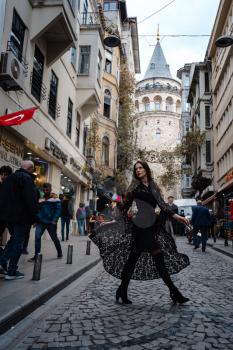Portrait of beautiful woman with view of Galata tower in Istanbul, Turkey. Travel and vacation in Turkey concept