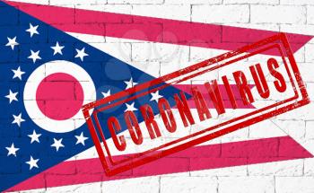 Flag of the State of Ohio painted on grungy brick wall background. with stamp CORONAVIRUS, idea and concept of healthcare, epidemic and disease in USA