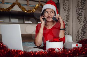 christmas, technology, people and online shopping concept. asian woman in santa helper hat with gift box, laptop computer and credit card over holidays lights background