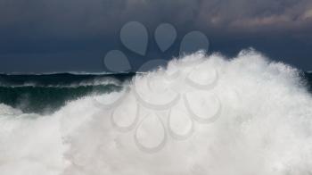 Frozen motion of large wave or breaker approaching shore and short shutter speed freezing the water into droplets
