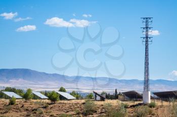 Row of solar panels and electricity pylon for power generation from the sun in remote locations in Southern Spain