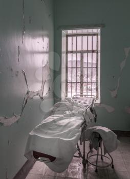 Bed or stretcher inside empty room in Trans-Allegheny Lunatic Asylum in Weston, West Virginia, USA