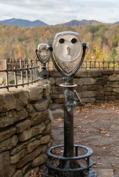 Rear view of coin operated binoculars or telescope in shape of a face at Hawks Nest State Park in fall colors
