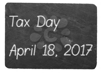 Tax submission day text message written in chalk on a chalky natural slate blackboard isolated against white background with copy space