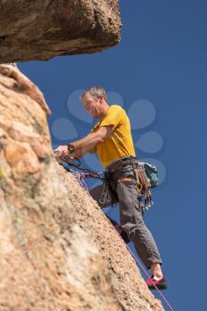 Senior male climber well equipped with cams and caribiners on Turtle Rocks near Buena Vista Colorado