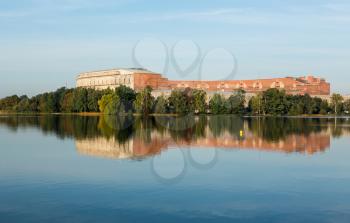The remains of the large Congress Hall or Kongresshalle at the Nazi Parade grounds and reflected in still lake in Nuremberg, Germany