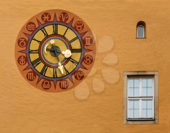 Ancient clock face on wall in the medieval town of Regensburg, Bavaria, Germany