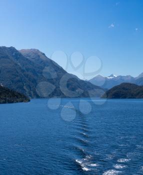 Sailing out of Doubtful Sound on South Island of New Zealand aboard a cruise ship showing strong headwinds behind the ship
