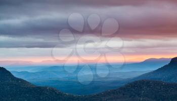 Rising sun illuminates clouds and mist in the valley from Echo Point overlooking the majestic Blue Mountains near Sydney NSW Australia