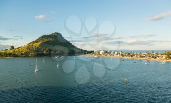 The bay and harbour at Tauranga with calm water in front of the Mount