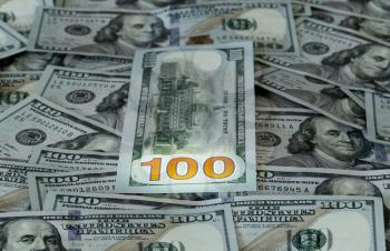 New design of US currency one hundred dollar bills laid out on table with focus on 100 numerals on back