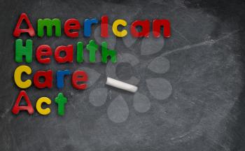 Childs magnetic letters spell American Health Care Act in congress. This is superimposed on a chalkboard or blackboard
