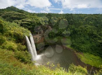 Sun illuminates the twin falls of Wailua waterfall on Hawaiian island of Kauai