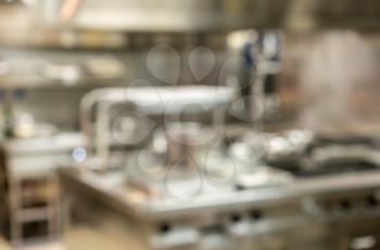 Defocused food being cooked in commercial stainless steel kitchen in restaurant
