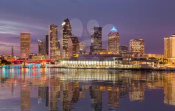 Florida skyline at Tampa with the Convention Center on the riverbank. Lights are reflected in a smooth artificial water  surface