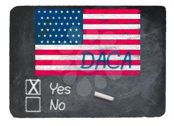 DACA Yes Vote message written in chalk on a chalky natural slate blackboard for current debate over Dreamers