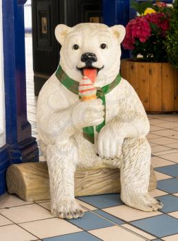 EASTBOURNE, UK - SEPTEMBER 19, 2016: Model statue of a polar bear licking an ice cream cone on the pier at Eastbourne, UK
