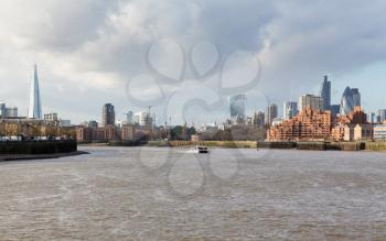 LONDON, UK - JANUARY 30, 2016: Skyline of the main office buildings in City of London with Thames Clipper ferry boat taken from  Canary Wharf, Docklands, London, England