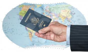 Senior executive hand holding US passport against blurred background of world map