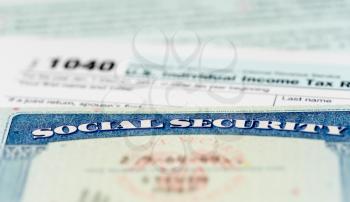 Social Security card in the USA laid on top of Form 1040 tax return of income in retirement
