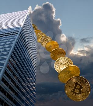 Bitcoin coins falling from the sky to illustrate the falling price of the cybercurrency from a financial building