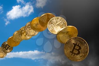 Bitcoin coins rising and falling from the sky to illustrate the falling price of the cybercurrency