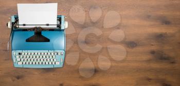 Modern electric typewriter on wooden desk background with copy space for hero header