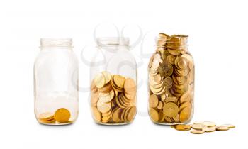 Three glass bottles with increasing amounts of gold coins to show how savings grow over time