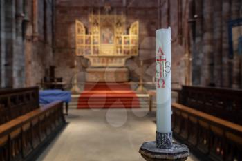 Interior and altar of Shrewsbury Abbey in Shropshire with a focus on an altar candle