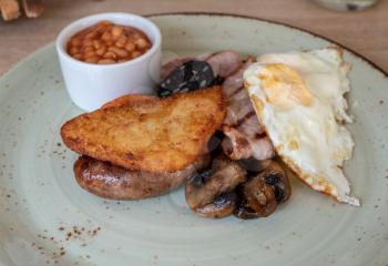 Plated full english or scottish breakfast on rustic plate in luxury hotel restaurant