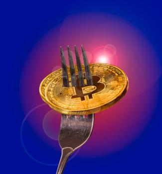Two macro bitcoins or bit coins impaled on a fork to illustrate a split into a new blockchain and altcoin