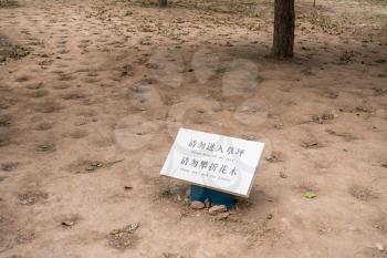 Funny message to keep off lawn and don't pick flowers in middle of bare dirt and soil
