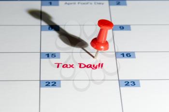 Tax day is April 15th for filing to IRS with red push pin in calendar for reminder