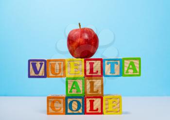 Vuelta al Cole translates to Back to School in spanish with wooden blocks with red apple on top