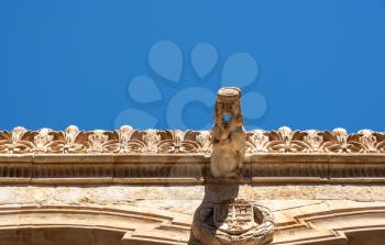 Ornate stone carvings on the roof and downspout at Casa de la Conchas or shells in Salamanca