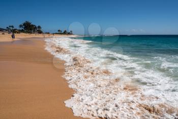 Holidaymakers on the sand of Sandy Beach on the east coast of Oahu in Hawaii in winter