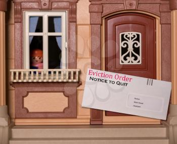 Envelope being served at toy dollhouse containing an eviction notice due to failure to pay rent on the property