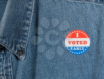 I Voted Early sticker or campaign button on the blue denim working shirt collar for elections in the USA