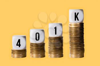 Rising value in retirement plan or 401K with blocks on stacks of gold coins on golden background
