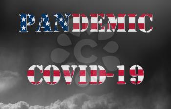 Pandemic warning of quarantine due to Covid-19 or corona virus in the USA using US flag lettering against dark cloudy storm clouds in the background