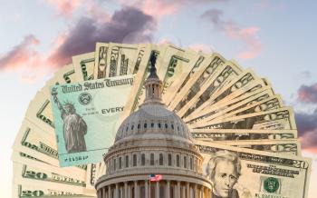 US Congress and Capitol dome in Washington DC with cash and check behind to illustrate coronavirus stimulus payment