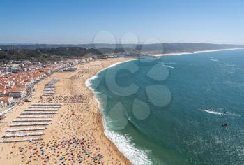 Crowded beach of Nazare from above with tourists relaxing on the sand